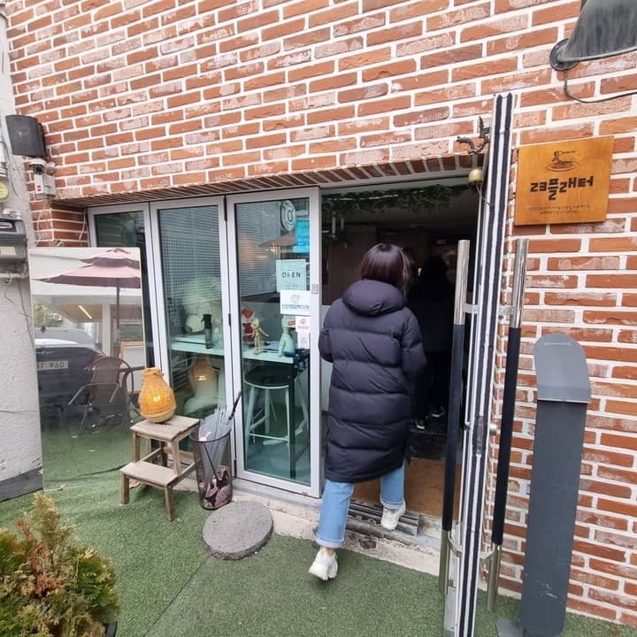 벽돌 외벽과 유리문이 보이는 23플래터 입구 — 뽈레 23플래터 공개 사진