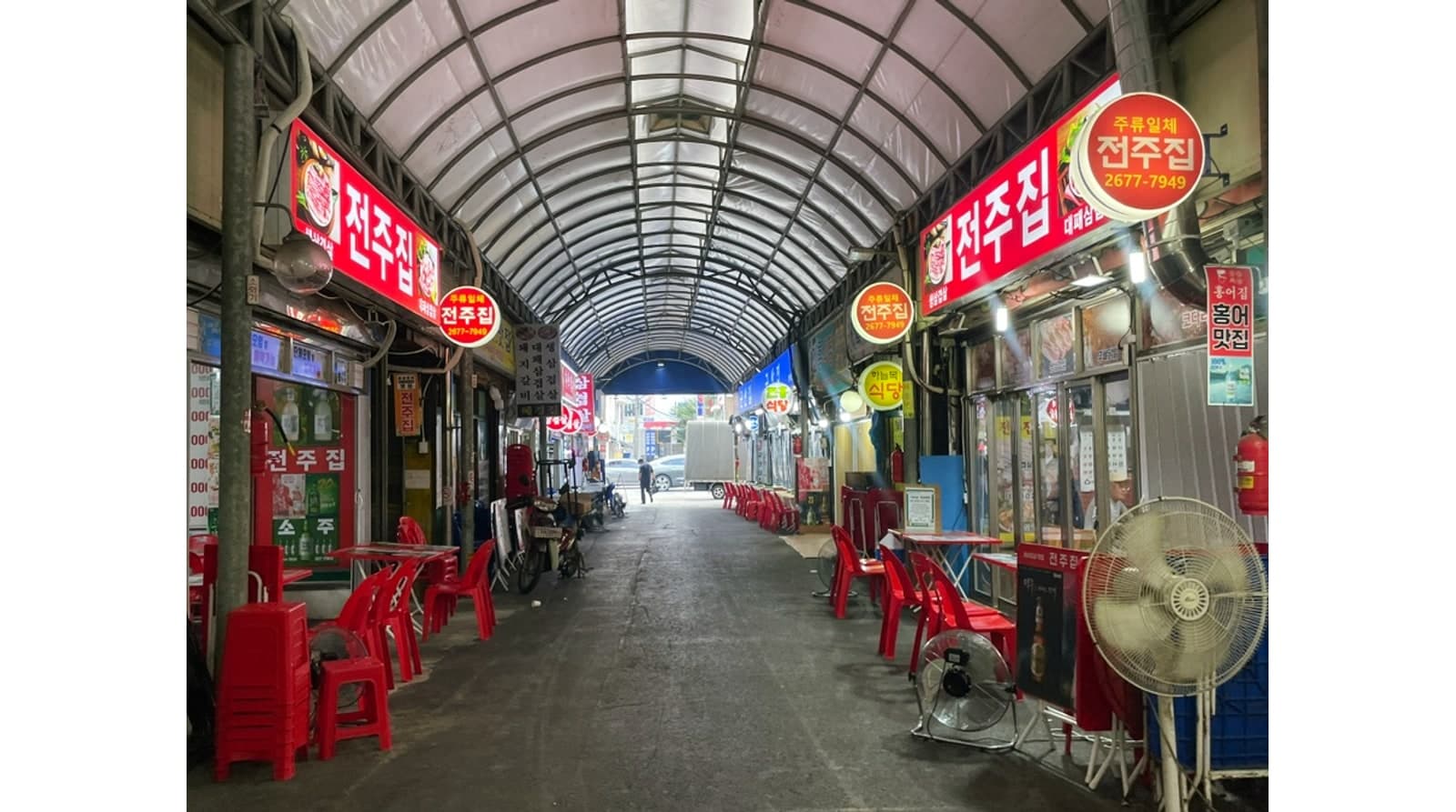 아케이드 지붕 아래로 이어지는 시장 골목 좌석 — 공개 방문 사진